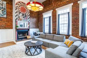 a living room with a couch and a brick wall at Heart of the Old City- Minutes from Market Square in Knoxville