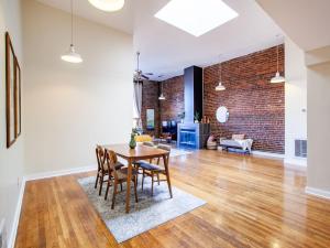 a dining room and living room with a brick wall at Spacious Old City Loft in Knoxville