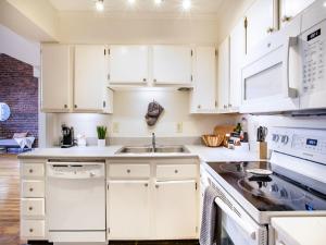 a kitchen with white cabinets and a sink at Spacious Old City Loft in Knoxville