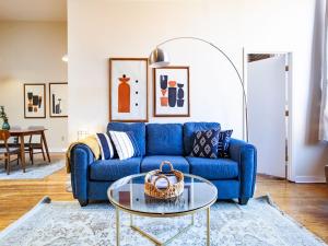 a blue couch in a living room with a glass table at Spacious Old City Loft in Knoxville
