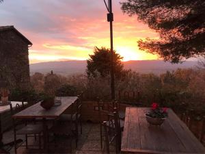 a wooden table and chairs with a sunset in the background at Malvarina in Capodacqua
