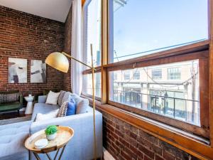 a living room with a couch and a large window at Modern Old City Loft - Downtown Knoxville in Knoxville
