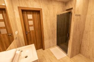 a bathroom with a shower and a sink and a mirror at Apartamenty ZYGFRYD 28C/1 in Bystrzyca Kłodzka