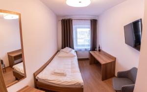 a small room with a bed and a mirror at Apartamenty ZYGFRYD 28C/1 in Bystrzyca Kłodzka
