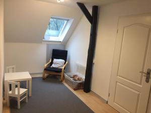 a attic room with a chair and a window at Ferienwohnung Reitanlage Bärenz in Selk