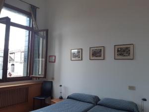 - une chambre avec un lit et une fenêtre dans l'établissement Foresteria Valdese Venezia, à Venise