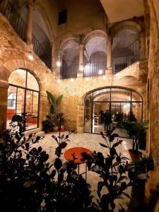 Palazzo Aprile في كالتاجيروني: غرفة كبيرة مع طاولة وبعض النباتات
