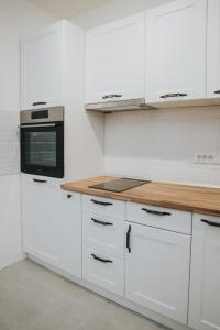 a kitchen with white cabinets and a stove top oven at My Home in Arandjelovac