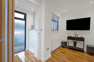 a living room with a flat screen tv on a wall at Pitcorthie House in Dunfermline