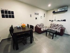 a living room with a table and a couch at Budget for 12 in Ipoh
