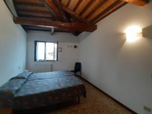 - une chambre avec un lit dans une pièce dotée d'une fenêtre dans l'établissement Foresteria Valdese Venezia, à Venise