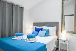 un letto blu e bianco con due cuscini sopra di Penthouse Filka a Mimice