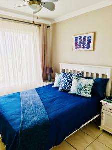 Una cama con sábanas azules y almohadas en un dormitorio en 199 Laguna La Crete, en Margate