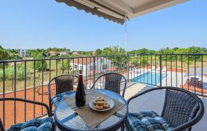 a table with a bottle of wine and a plate of food on a balcony at Apartmani Lucija in Poreč