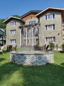 a fountain in front of a large building at Hotel Outlook - Pahalgam in Pahalgām