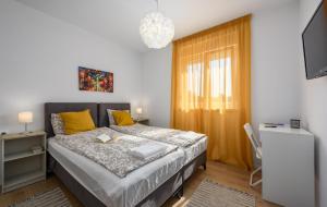 a bedroom with a bed with yellow pillows and a television at Apartmani Lucija in Poreč +62 photos