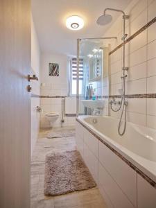 uma casa de banho com uma banheira, um lavatório e um WC. em Ferienwohnung in der Sportstadt Riesa em Riesa