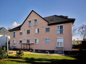 un grand bâtiment rose avec un toit noir dans l'établissement Ferienwohnung in der Sportstadt Riesa, à Riesa 9 autres photos