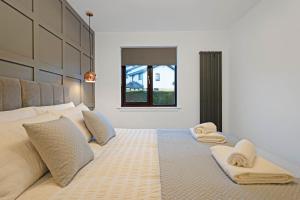 - une chambre avec un grand lit et des serviettes dans l'établissement Pitcorthie House, à Dunfermline