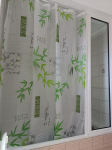 a bathroom window with a shower curtain with bamboo at DESPOINA APARTMENT with garden in Néa Michanióna