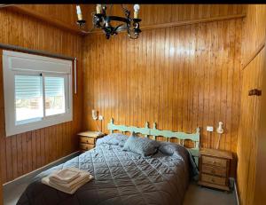 - une chambre avec un lit dans un mur en bois dans l'établissement La casa de madera, à Cómpeta