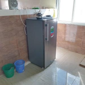 - un petit réfrigérateur dans une cuisine avec deux paniers dans l'établissement Abu Omair Jabal Shams House, à Al Hamra