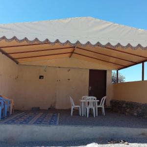 une terrasse avec une table et des chaises sous une tente dans l'établissement Abu Omair Jabal Shams House, à Al Hamra
