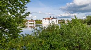 ein großes weißes Gebäude auf einem See in der Unterkunft Ferienwohnung an der Rosenterrasse - Meerblick in Glücksburg