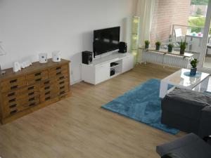 a living room with a flat screen tv on a dresser at Fördeblick-Wassersleben in Harrislee