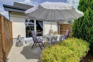 un patio con mesa y sillas bajo una sombrilla en Ferienwohnung Aneta, en Flensburg