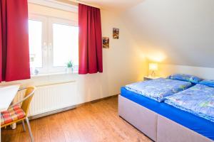 a bedroom with a bed and a table and a window at Ferienwohnung Viola in Glücksburg