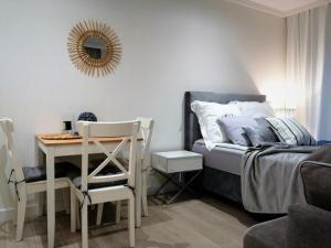 a bedroom with a bed and a table and a mirror at Apartament Baltic Residence Nr 5 in Pobierowo