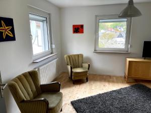 a living room with two chairs and two windows at Maisonettchen in Holzhausen