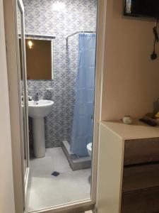 a bathroom with a shower and a toilet and a sink at Verona Apartment in Dushetʼi