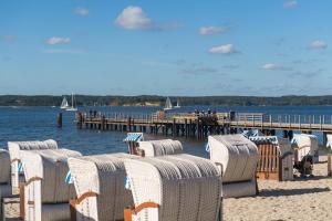 a group of chairs on the beach next to a pier at Appartement Tim in Glücksburg