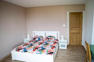 1 dormitorio con 1 cama con un edredón colorido en Maison de charme dans un Hameau Provençal, en Les Mées