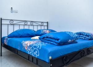 a bed with blue sheets and blue pillows on it at Nature Lanka Guest House in Negombo