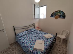 a bedroom with a bed and a table and a chair at Villetta Alka, INTERA casa indipendente in Torre dell'Orso