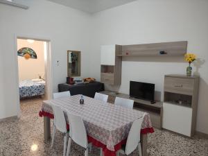 a room with a table and chairs and a bedroom at Villetta Alka, INTERA casa indipendente in Torre dell'Orso