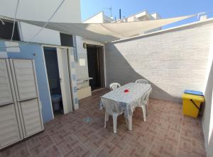 a patio with a table and chairs in a room at Villetta Alka, INTERA casa indipendente in Torre dell'Orso
