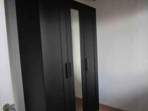 a pair of black closet doors in a room at Le Petit Chalet in Resteigne