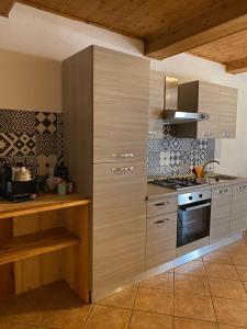 - une cuisine avec des placards en bois et une cuisinière dans l'établissement casa vacanze B&B ilciliegio, à Bovegno