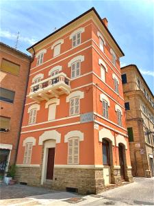 an orange building with a balcony on the side of it at B&B Terrazza Sul Borgo in Mogliano