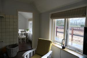 a kitchen with a window and a dining room with a table at Tiny house Veluwse Garre in Garderen