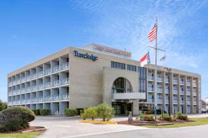 una vista exterior de un hotel con bandera americana en Travelodge by Wyndham Outer Banks/Kill Devil Hills, en Kill Devil Hills