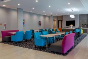 ShorewoodにあるLa Quinta Inn & Suites by Wyndham Shorewoodのダイニングルーム(テーブル、カラフルな椅子付)