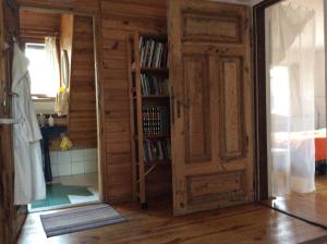 a room with a book shelf and an open door at Pokój w domu z ogrodem w Milanówku in Milanówek