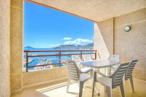 einen Tisch und Stühle auf einem Balkon mit Meerblick in der Unterkunft Homeincalpe Rosamarina 9C in Calpe