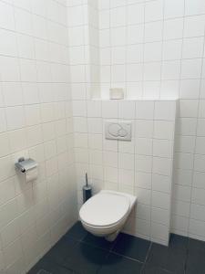 a bathroom with a toilet in a white tiled wall at Stiftstaverne Klein Mariazell in Kleinmariazell