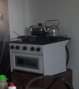 a stove with a pot and pans on top of it at Departamento Yokavil in Santa María
